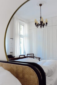 beżowa sypialnia okrągłe lustro ratanowe czarne łóżko inspiracje - 1